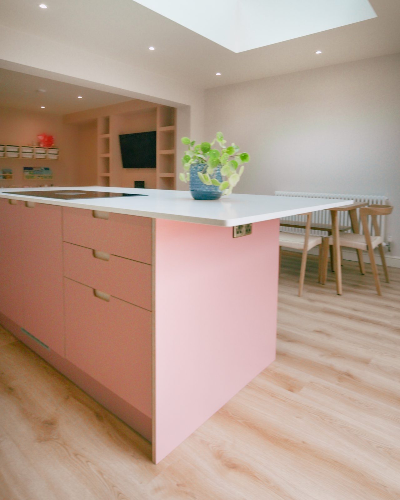Pink island kitchen with dining area by JWA Building Services